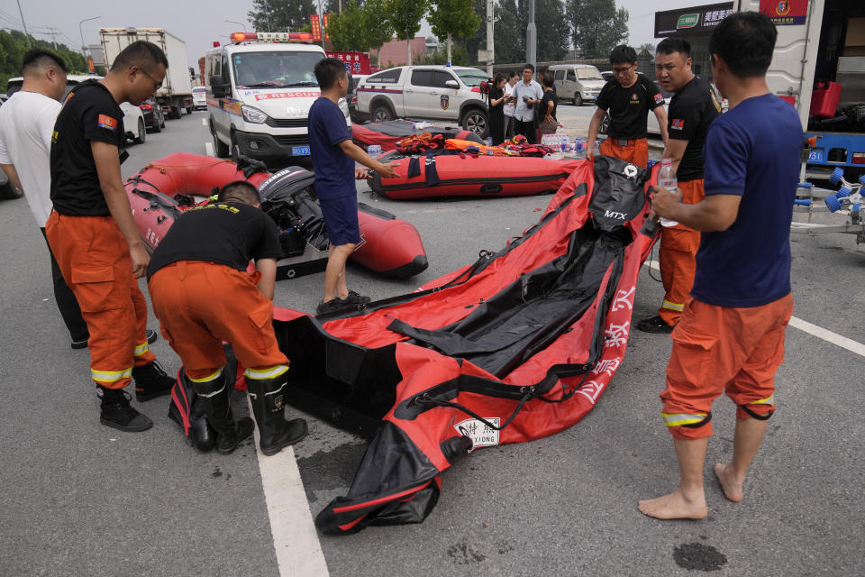 Rescuers prepare rubber boats to evacuate trapped residents from flooding in Zhuozhou in northern China's Hebei province, south of Beijing, Wednesday, Aug. 2, 2023. China's capital has recorded its heaviest rainfall in at least 140 years over the past few days. Among the hardest hit areas is Zhuozhou, a small city that borders Beijing's southwest. (AP Photo/Andy Wong)