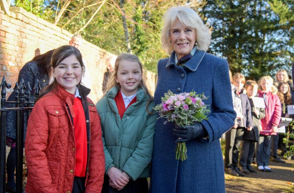 The Duchess of Cornwall received a posy of flowers from local primary school pupils Florence Crossman and Lily King (Finnbarr Webster/PA) (PA Wire)