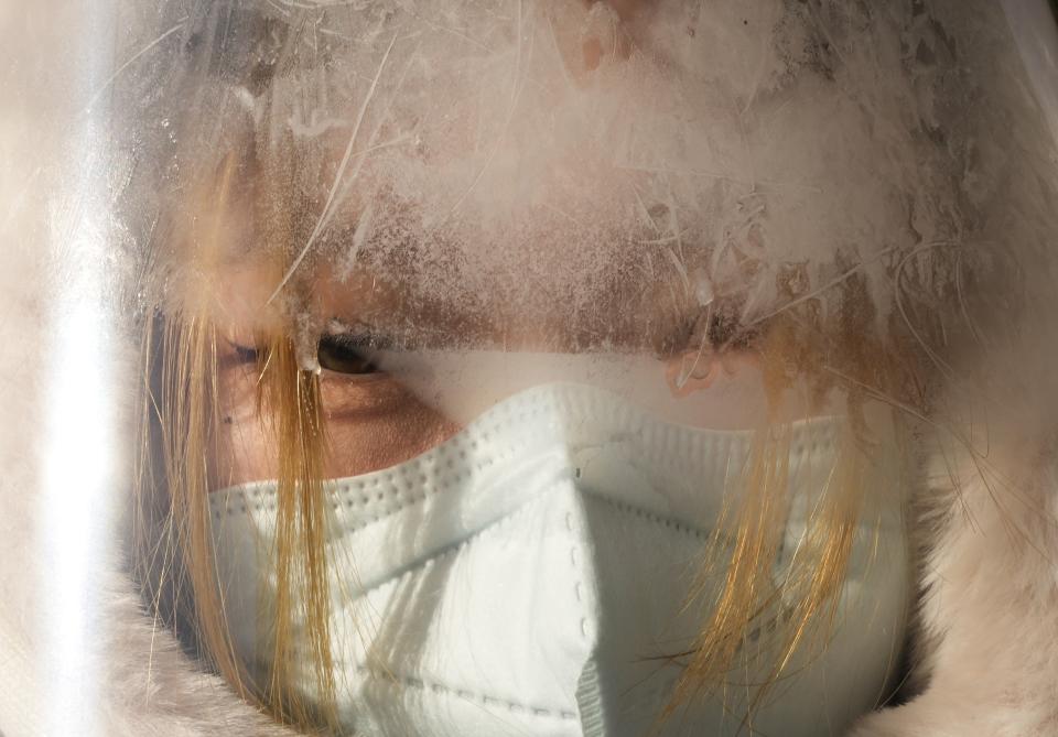 Frost covers a face shield of a volunteer before the start of the women's 7.5km + 7.5km skiathlon cross-country skiing competition at the 2022 Winter Olympics, Saturday, Feb. 5, 2022, in Zhangjiakou, China. (AP Photo/Alessandra Tarantino)