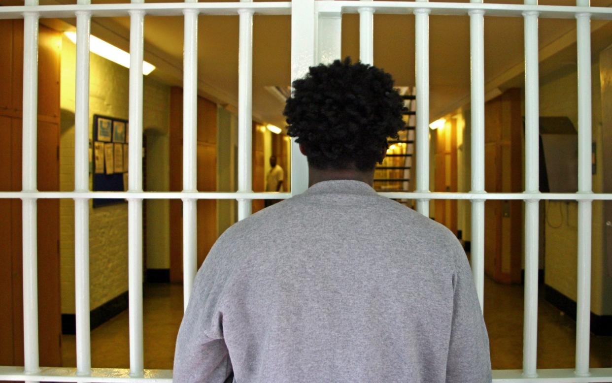 Prisoner looking through cell bars