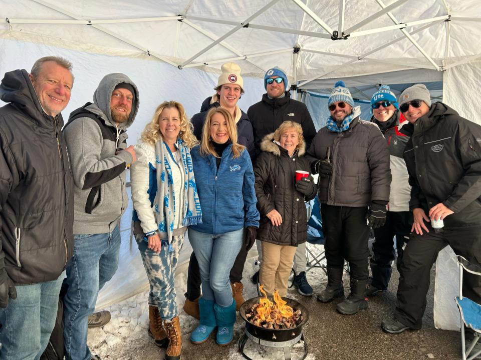 Eric Thornton, 34, of Romeo, dons blue glasses and a blue hat in front of a fire pit set up to stay warm as he joined family and friends for their tailgating tradition Sunday, Jan.14, 2024 for the Lions’ playoff game.