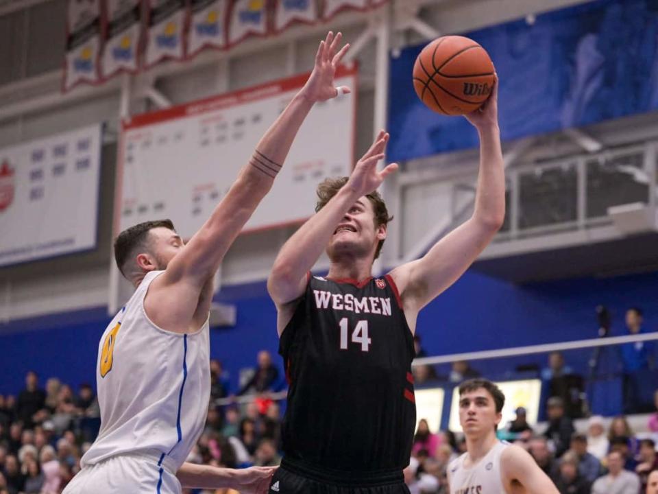 University of Winnipeg Wesmen forward Mikhail Mikhailov tries to get a shot away as Dominick Olivieri of the University of Victoria Vikes defends during the Canada West men's basketball championship game at the CARSA Performance Gym in Victoria on Friday night. (Submitted by Matt Macsemniuk - image credit)