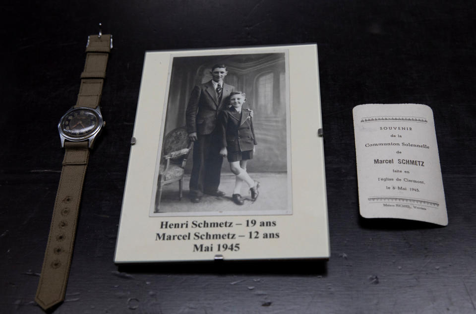 In this photo taken on Tuesday, May 5, 2020, a photo of brothers Henri Schmetz and Marcel Schmetz, is placed next to a watch given to Marcel Schmetz from and American WWII soldier at the Remember Museum 39-45 in Thimister-Clermont, Belgium. Schmetz now runs a war museum with his wife Mathilde, right where the Battle of the Bulge, Hitler's last stand to change the tide of the war, took place. But what was supposed to be the highlight of the year is now spent in isolation with Mathilde behind closed doors of the museum. (AP Photo/Virginia Mayo)