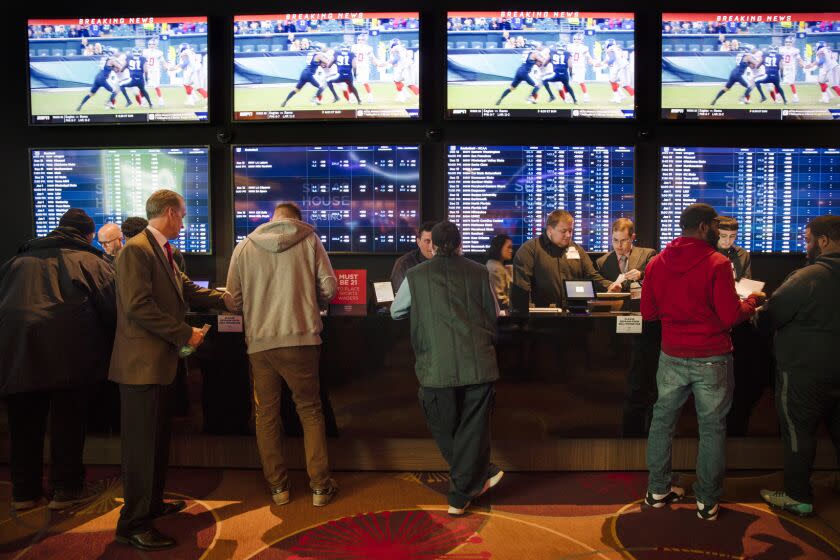 FILE - In this Thursday, Dec. 13, 2018, file photo, gamblers place bets in the temporary sports betting area at the SugarHouse Casino in Philadelphia. The federal government would regulate sports betting nationwide under a bill to be introduced Wednesday, Jan. 19,2018. The bill would have the U.S. Justice Department set minimum standards states must meet in order to offer sports betting, but denies the sports leagues the so-called "integrity fees" they have been seeking in new legislation, essentially a cut of sport betting revenue. (AP Photo/Matt Rourke, File)