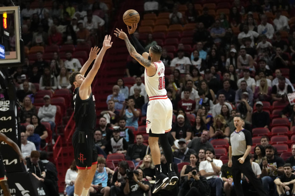 Miami Heat forward Caleb Martin (16) shoots as Houston Rockets center Alperen Sengun, left, defends during the first half of an NBA basketball game, Friday, Feb. 10, 2023, in Miami. (AP Photo/Lynne Sladky)
