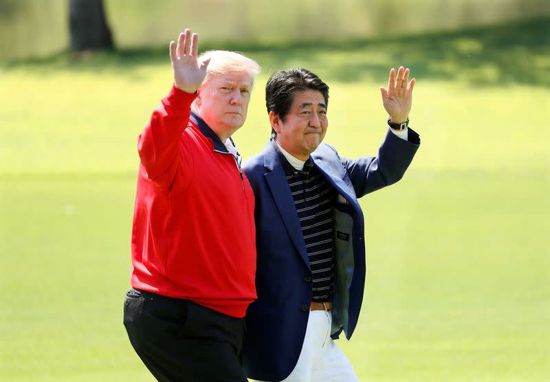FILE PHOTO: FILE PHOTO: U.S. President Donald Trump and Japanese Prime Minister Shinzo Abe wave on the way to the course to play golf at Mobara Country Club in Mobara, Chiba Prefecture