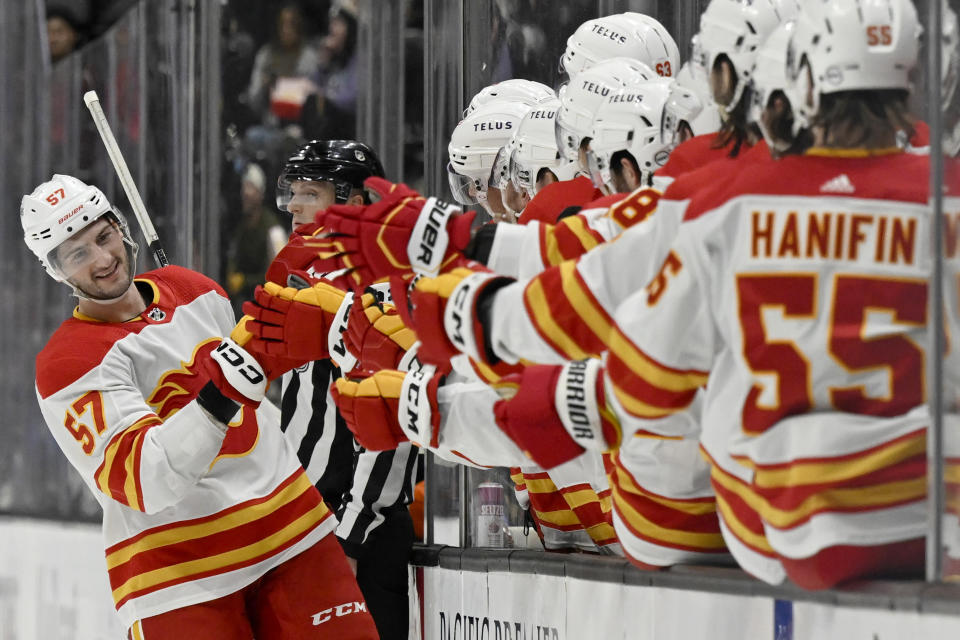 Calgary Flames defenseman Nick DeSimone, left, celebrates with teammates after scoring against the Anaheim Ducks during the first period of an NHL hockey game in Anaheim, Calif., Thursday, Dec. 21, 2023. (AP Photo/Alex Gallardo)