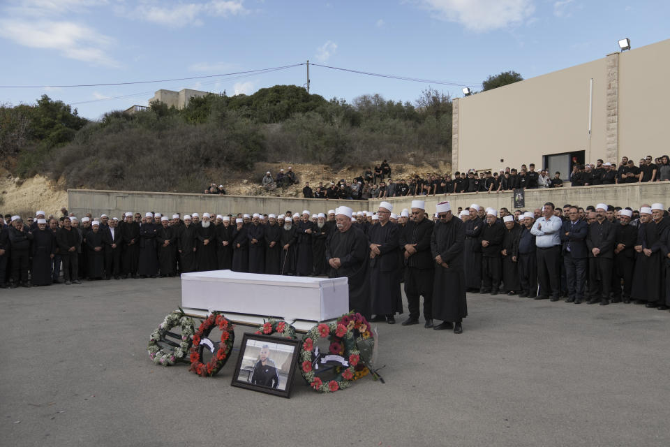 Members of the Israeli Druze minority gather around the body of Tiran Fero, 17, during his funeral in Daliyat al-Carmel, Israel, Thursday, Nov. 24, 2022. Fero's body, which was taken on Wednesday by Palestinian militants from a West Bank hospital where he was seeking treatment after a car accident, was returned to his family on Thursday. (AP Photo/Mahmoud Illean)