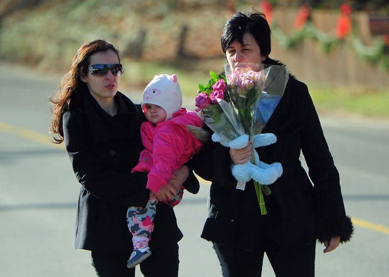 Residents arrive to pay tribute to the victims of an elementary school shooting in Newtown, Connecticut, on December 15, 2012. The US school gunman used an assault rifle to pump his mostly six- and seven-year old victims with multiple bullets, authorities said Saturday, as details of the horrific spree became clearer