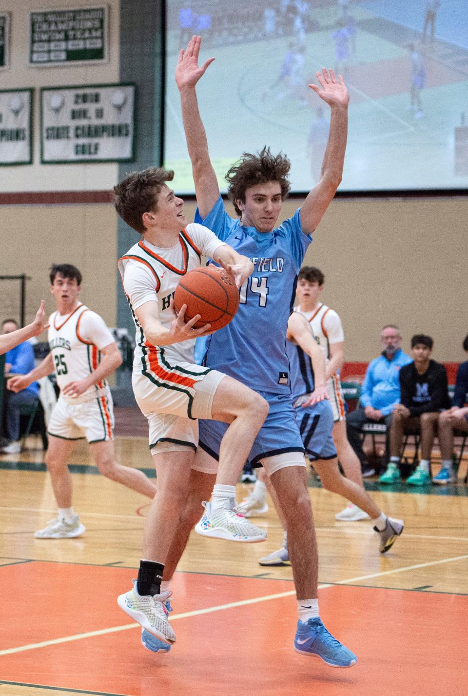 Hopkinton senior captain Jack Ianelli goes in for a layup around Medfield senior Jack Iovino during the game in Hopkinton, Feb. 6, 2024. The Hillers beat the Big Blue, 79-57.