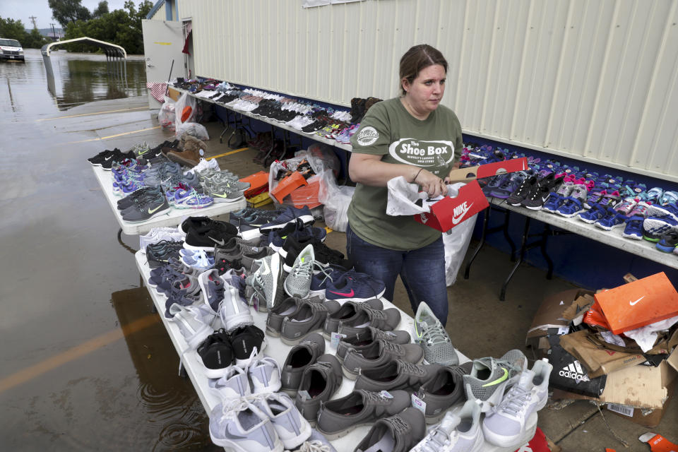 Rachel Carlson, was one of the many employees of the Shoe Box in Black Earth carrying shoes outside to dry off after flood waters from the Black Earth Creek flooded the area Tuesday, Aug. 21, 2018. (Steve Apps/Wisconsin State Journal via AP)