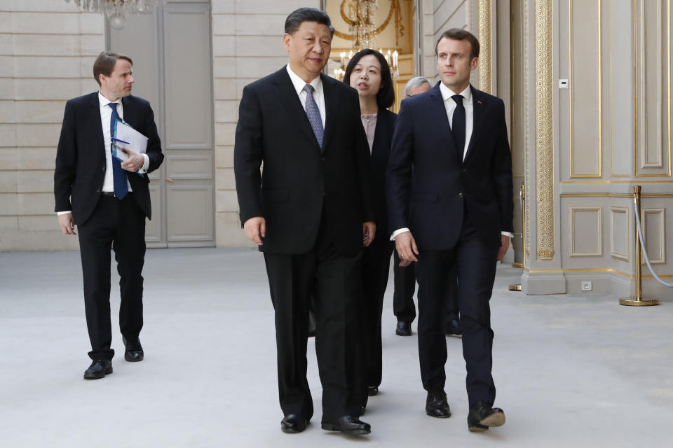 French President Emmanuel Macron, right, and his Chinese counterpart Xi Jinping arrive for a press conference with German Chancellor Angela Merkel and European Commission President Jean-Claude Juncker at the Elysee presidential palace in Paris, Tuesday, March 26, 2019. Xi Jinping is meeting with the leaders of France, Germany and the European Commission, as European countries seek to boost relations with China while also putting pressure over its trade practices. (AP Photo/Thibault Camus, Pool)