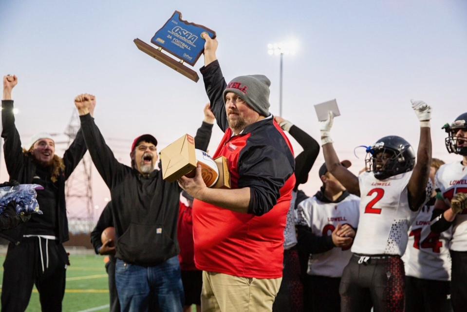 Lowell head coach Ray Yarbrough raises the trophy after the Devils beat Weston-McEwen to win the OSAA Class 2A state championship at Hillsboro Stadium Saturday, Nov. 25, 2023, in Hillsboro.