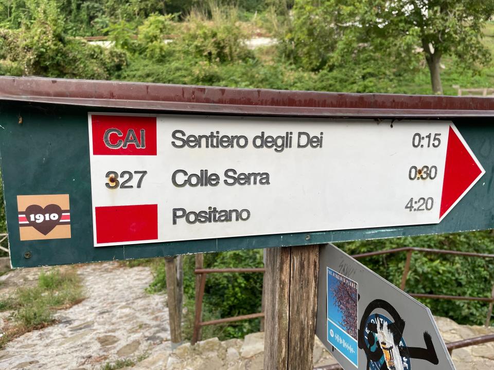 A sign with directions to Sentiero degli Dei, Colle Serra, and Positano.