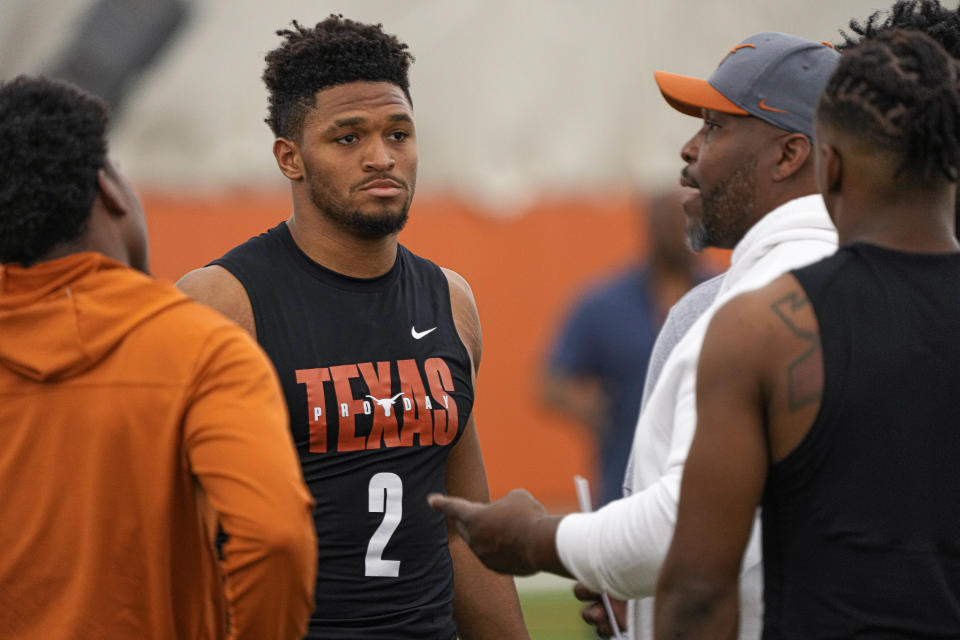 Texas running back Roschon Johnson listens to a coach's advice before participating in UT's annual pro timing day for NFL scouts on March 9. Fellow Longhorns running back Bijan Robinson is getting most of the attention, but Johnson is hoping to get taken in the NFL draft later this month.