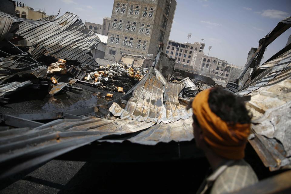 FILE - In this Thursday, Sept. 17, 2015, file photo, a worker looks at a chocolate factory destroyed by a Saudi-led airstrike in Sanaa, Yemen. Envoys from Yemen’s warring parties are headed to Sweden for another round of peace talks to stop the three-year-old war, but with few incentives to compromise, expectations are low for little more than improving a faltering de-escalation.(AP Photo/Hani Mohammed, File)