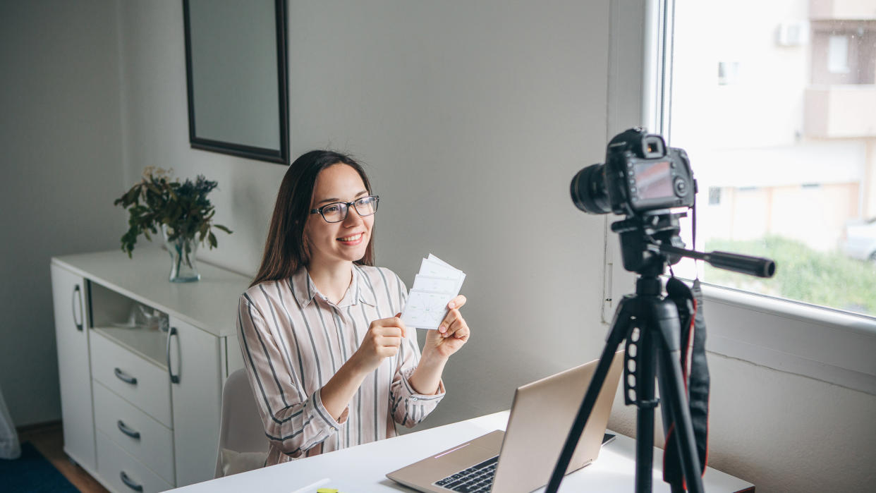 Girl video blogger or online foreign language teacher writes a training video for their subscribers to upload to social networks.