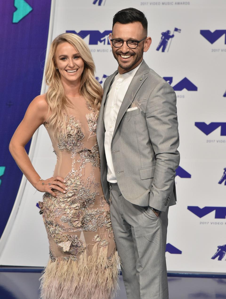 Leah Messer looks dazzling in a see-through dress with silver designs and fur beside ex-husband Jeremy, who is dressed in grey suit and pant to match