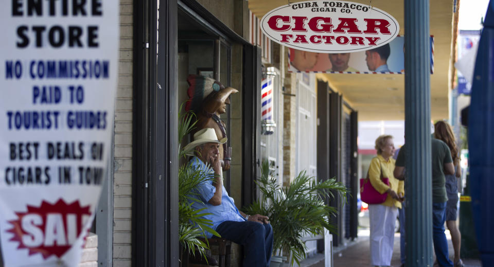 Don Pedro Bello sits in front of his cigar factory, Cuba Tobacco Company, in Miami's Little Havana section, Tuesday, Oct. 16, 2012, waiting for customers. Most members of MIami's Cuban community had little to say about Cuba relaxing travel restrictions. The Cuban government has announced that it will no longer require islanders to apply for an exit visa, eliminating a much-loathed bureaucratic procedure that has been a major impediment for many seeking to travel overseas for more than a half-century. A notice published in Communist Party newspaper Granma said the change takes effect Jan. 14, and beginning on that date islanders will only have to show their passport and a visa from the country they are traveling to. It is the most significant advance this year in President Raul Castro's five-year plan of reform that has already seen the legalization of home and car sales and a big increase in the number of Cubans owning private businesses.(AP Photo/J Pat Carter)