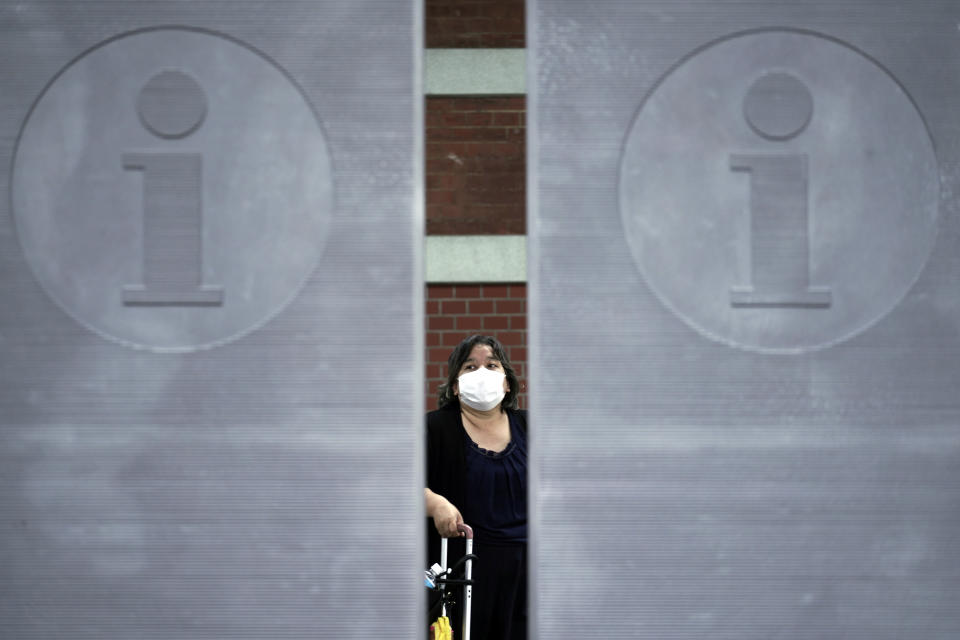 A woman wearing a face mask to help curb the spread of the coronavirus walks Monday, July 13, 2020, in Tokyo. The Japanese capital has confirmed more than 100 new coronavirus infections on Monday. (AP Photo/Eugene Hoshiko)