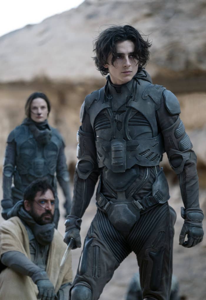 Timothée Chalamet with a spear in his hand, alongside Rebecca Ferguson and Javier Bardem, in "Dune"