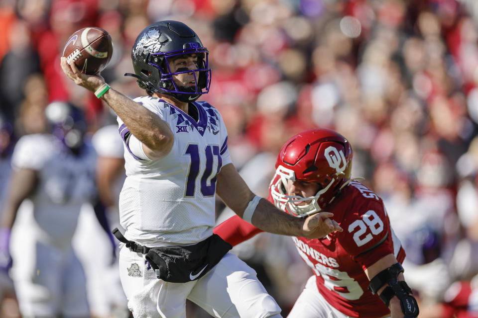 TCU quarterback Josh Hoover (10) passes under pressure by Oklahoma linebacker Danny Stutsman (28) during the first half of an NCAA college football game Friday, Nov. 24, 2023, in Norman, Okla. (AP Photo/Alonzo Adams)