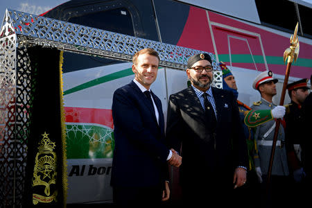 French President Emmanuel Macron and Moroccan King Mohammed VI shake hands as they inaugurate a high-speed line at Rabat train station, in Rabat, France November 15, 2018. Christophe Archambault/Pool via Reuters