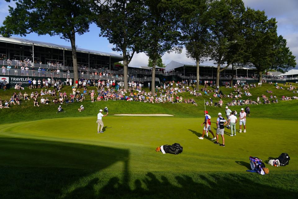 Chez Reavie, left, gestures to fans after his putt on the 18th green during the third round of the Travelers Championship golf tournament at TPC River Highlands, Saturday, June 24, 2023, in Cromwell, Conn. (AP Photo/Frank Franklin II)