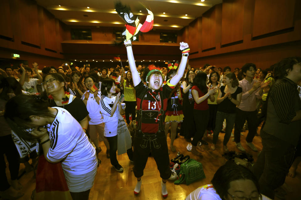 Fans of Germany's national soccer team celebrate as they watch a live broadcast of the World Cup final match between Germany and Argentina at the Goethe Institute in Tokyo, Monday, July 14, 2014. Germany won 1-0 over Argentina. (AP Photo/Eugene Hoshiko)