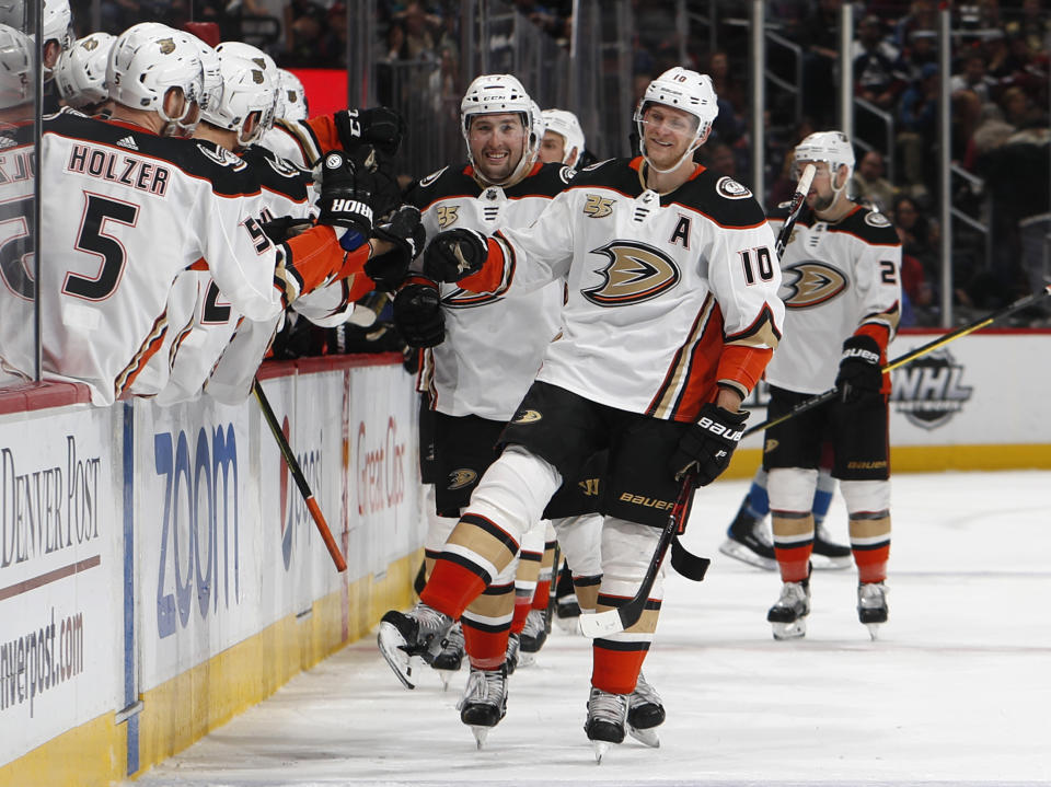 FILE - In this March 15, 2019, file photo, Anaheim Ducks right wing Corey Perry, right, is congratulated as he passes the team box after scoring the go-ahead goal against the Colorado Avalanche during the third period of an NHL hockey game, in Denver. The Anaheim Ducks have bought out the contract of former NHL MVP Corey Perry after 14 seasons with the franchise. The Ducks announced the move Wednesday, June 19, 2019. General manager Bob Murray called it "one of the most difficult decisions I've had to make in my 44 years in the NHL." (AP Photo/David Zalubowski, File)