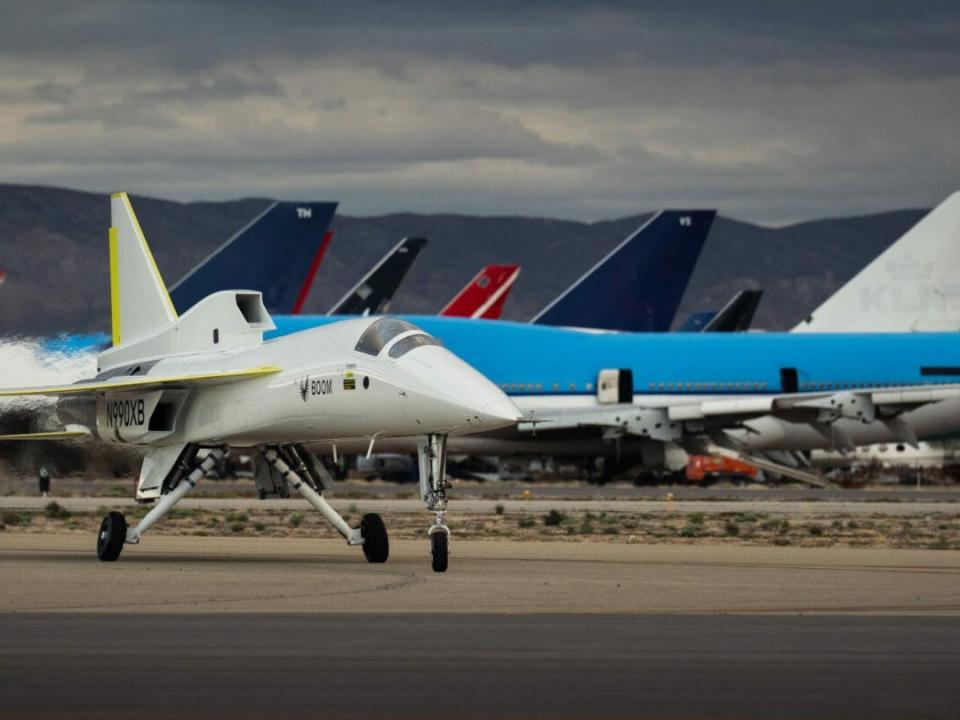 The XB-1 aircraft in front of abandoned planes in the Mojave Desert's aircraft graveyard.