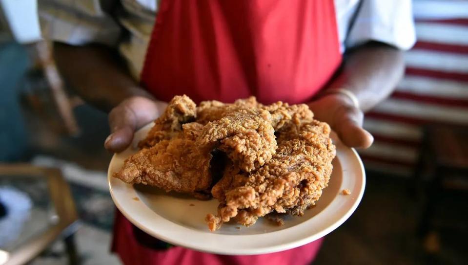 Arthur “Mr. D.” Davis holds a plate of his famous fried chicken inside the Old Country Store restaurant in Lorman.