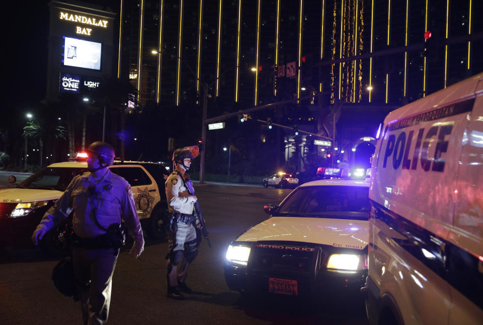 Police officers stand along the Las Vegas Strip the Mandalay Bay resort and casino during a shooting near the casino, Sunday, Oct. 1, 2017, in Las Vegas. (AP Photo/John Locher)