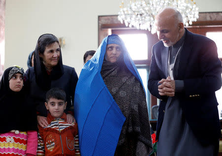 Afghanistan's President Ashraf Ghani speaks to Sharbat Gula, the green-eyed "Afghan Girl" whose 1985 photo in National Geographic became a symbol of her country's wars, after she arrived in Kabul, Afghanistan November 9, 2016. REUTERS/Mohammad Ismail