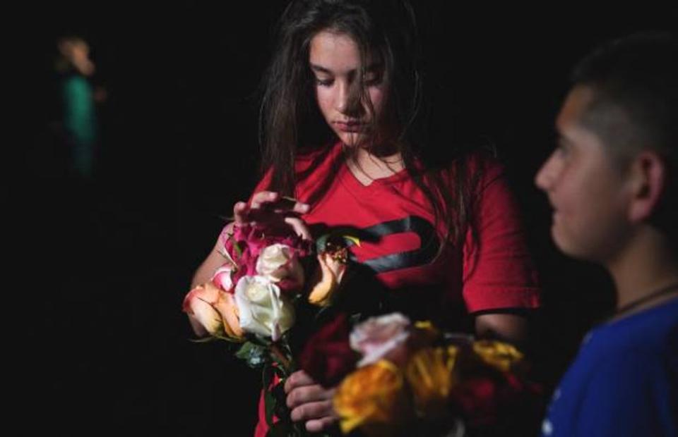 A young girl holds flowers outside the Willie de Leon Civic Center where people gather to mourn 19 children killed in the school shooting in Texas on Tuesday (AFP via Getty Images)