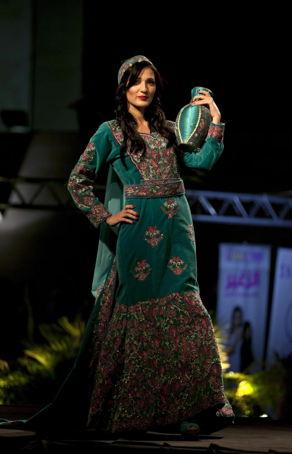 In this photo taken Thursday, May 1, 2014, a model displays a blend of traditional Palestinian embroidery and modern designs in a creation by designer Intisar Abdo during the opening day of the Palestine Fashion Week 2014, in the West Bank city of Ramallah. (AP Photo/Nasser Nasser)