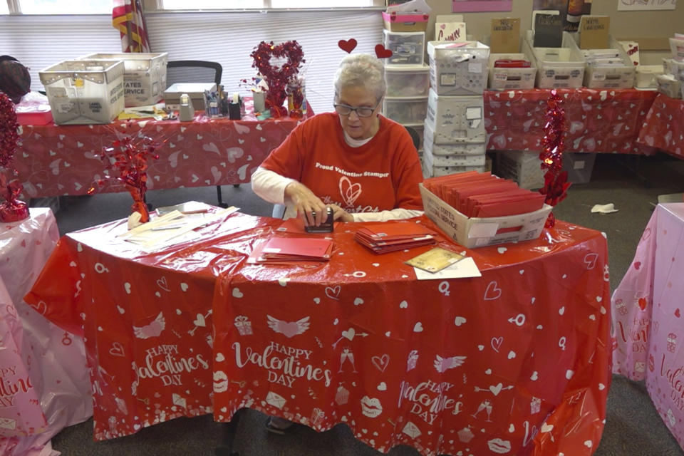 A volunteer stamps Valentine’s Day cards in Loveland, Colo., on Wednesday, Feb. 7, 2024. Every year, tens of thousands of people from around the world route their Valentine’s Day cards to the “Sweetheart City” to get a special inscription and the coveted Loveland postmark. The re-mailing tradition has been going on for nearly 80 years and is the largest of its kind in the world. (AP Photo/Thomas Peipert)