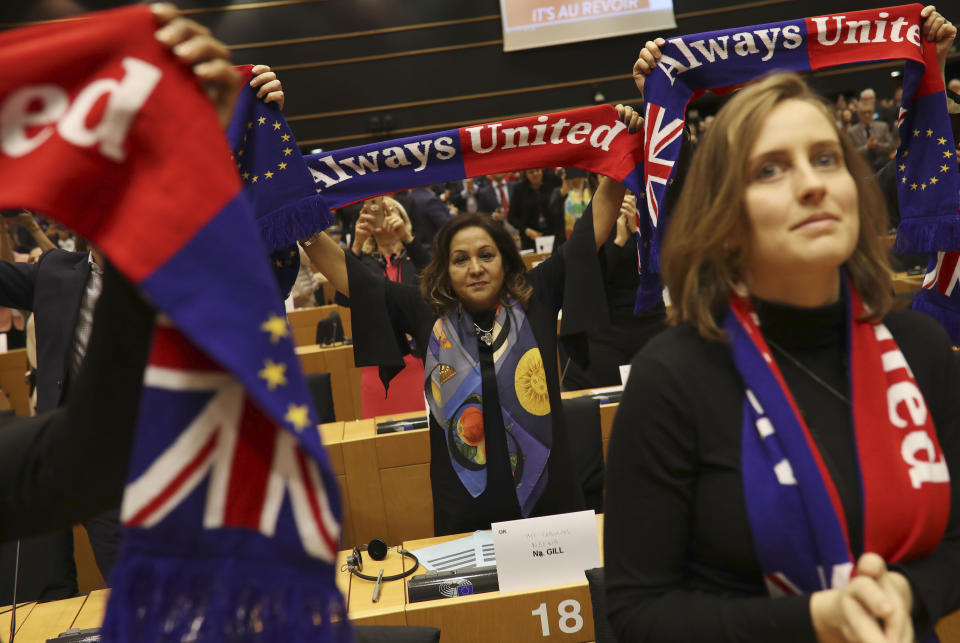 British MEP's hold up scarves during a ceremony prior to the vote on the UK's withdrawal from the EU, the final legislative step in the Brexit proceedings, at the European Parliament in Brussels, Wednesday, Jan. 29, 2020. The U.K. is due to leave the EU on Friday, Jan. 31, 2020, the first nation in the bloc to do so. (AP Photo/Francisco Seco)