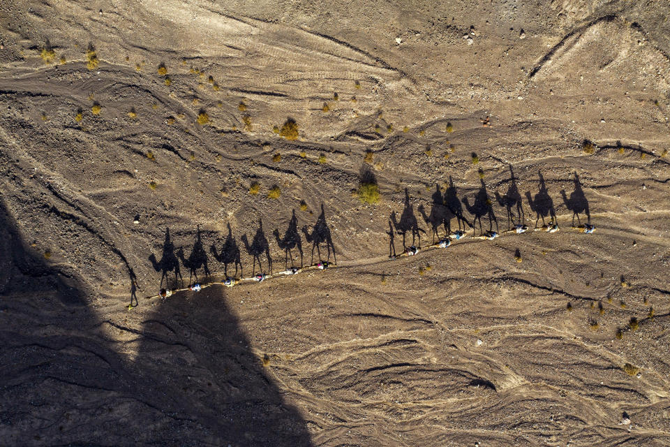 People ride on camels during the Jewish holiday of Hanukkah, in the desert near the southern Israeli city of Eilat, Thursday, Dec. 26, 2019. (AP Photo/Oded Balilty)