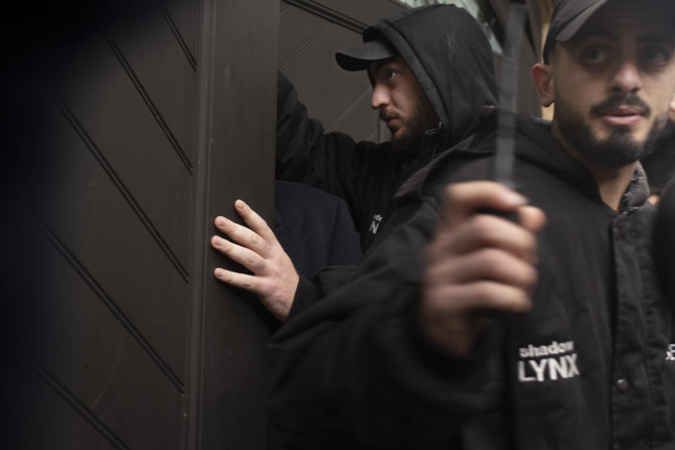 Private security guards secure a garage door to the home of former Nissan Chairman Carlos Ghosn in Beirut, Lebanon, Thursday, Jan. 2, 2020. Turkish authorities have detained seven people as part of an investigation into how Ghosn, who skipped bail in Japan, was able to flee to Lebanon via Istanbul, Turkish media reported Thursday. (AP Photo/Maya Alleruzzo)