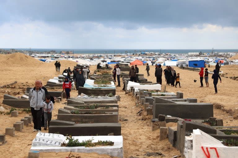 Palestinos en tumbas de familiares en la festividad de Eid al-Fitr, que marca el fin del Ramadán, en un cementerio en Rafah, en Gaza. (AFP)