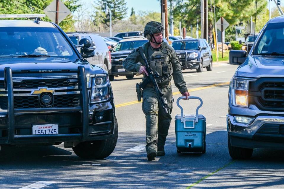An officer pulls an ice chest after gunfire erupted at the Hazel Ranch apartment complex in the 8800 block of Winding Way in Fair Oaks on Friday. Renée C. Byer/rbyer@sacbee.com