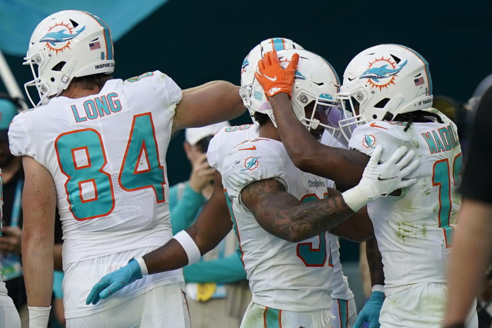 Miami Dolphins running back Myles Gaskin (37) celebrates with teammate Jaylen Waddle (17) after scoring a touchdown during the second half of an NFL football game against the Carolina Panthers, Sunday, Nov. 28, 2021, in Miami Gardens, Fla. (AP Photo/Lynne Sladky)