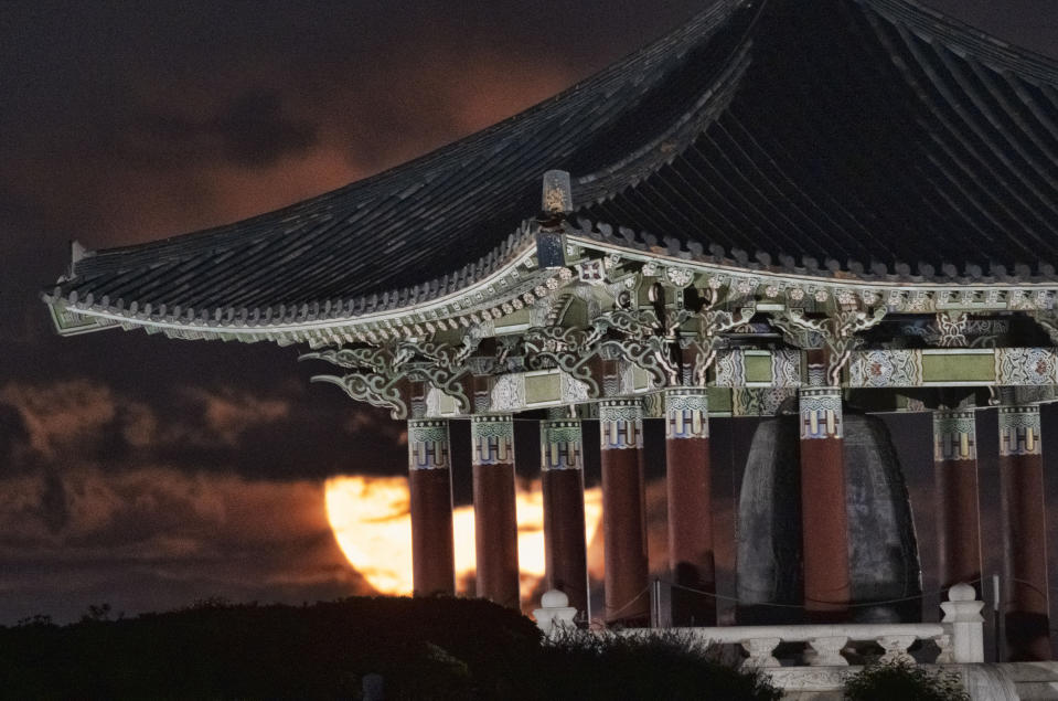 A full Sturgeon moon rises behind the Korean Bell of Friendship pavilion in Angel’s Gate Park, in the San Pedro neighborhood of Los Angeles on Tuesday, Aug. 1, 2023. (AP Photo/Richard Vogel)