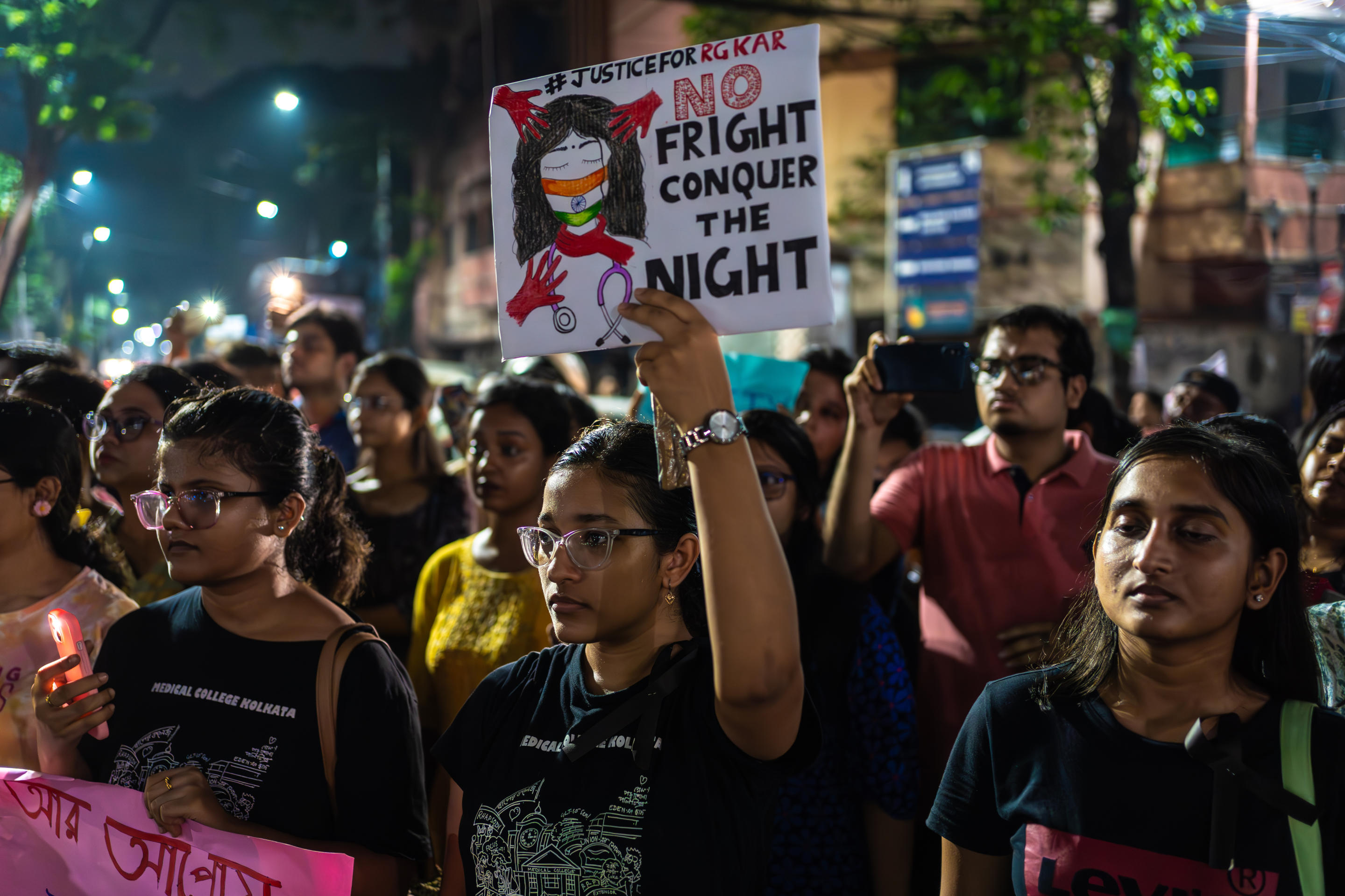 A protester holds a poster decrying violence against women. 