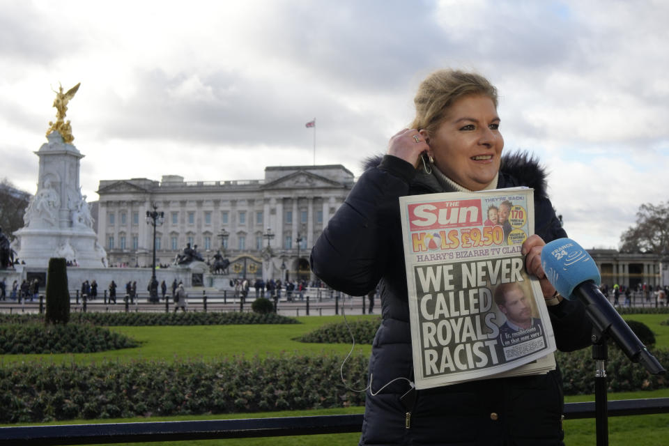 A journalist holds up a copy of a UK newspaper as she reports outside Buckingham Palace in London, Monday, Jan. 9, 2023. Prince Harry has defended his memoir that lays bare rifts inside Britain's royal family. He says in TV interviews broadcast Sunday that he wanted to "own my story" after 38 years of "spin and distortion" by others. Harry's soul-baring new memoir, "Spare," has generated incendiary headlines even before its release. (AP Photo/Kirsty Wigglesworth)