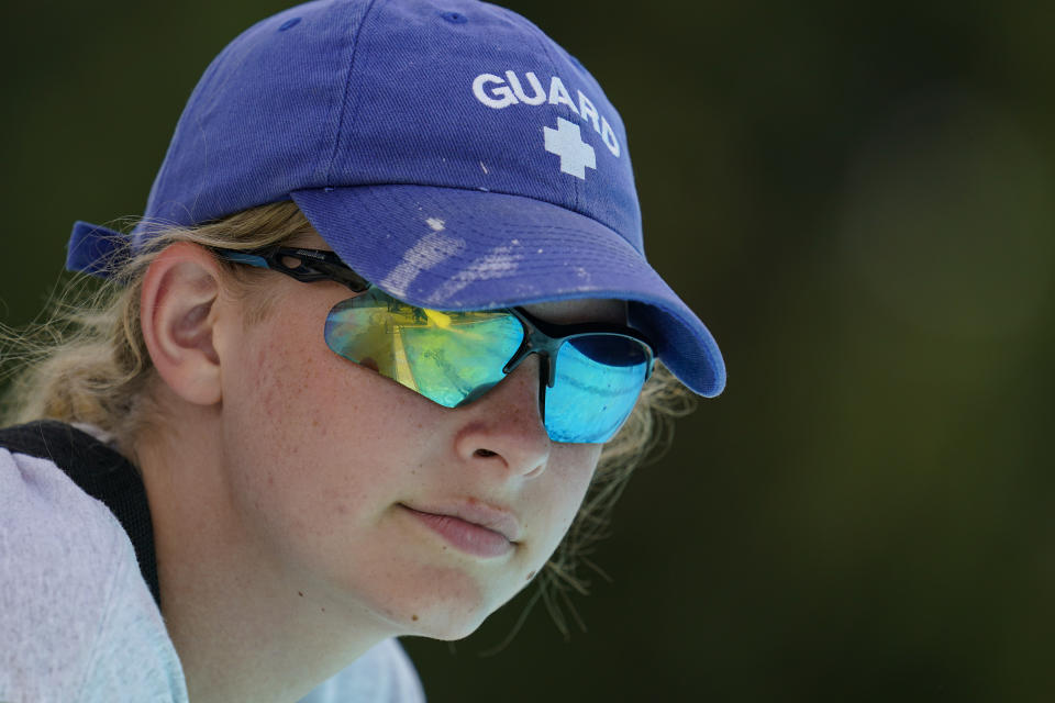 Lifeguard Elizabeth Conley keeps an eye on the swimmers at the Douglass Park pool in Indianapolis, Friday, June 17, 2022. Indianapolis typically fills 17 pools each year, but with a national lifeguard shortage exacerbated by the COVID-19 pandemic, just five are open this summer. The American Lifeguard Association estimates one-third of pools in the United States are impacted by the shortage. (AP Photo/Michael Conroy)