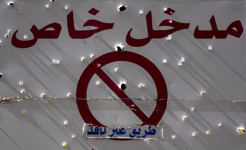 A sign with Arabic that read: "Private entrance, Dead end," is riddled with bullet holes after the deadly clashes that erupted last Thursday along a former 1975-90 civil war front-line between Muslim Shiite and Christian areas, in Ain el-Rumaneh neighborhood, Beirut,Lebanon, Tuesday, Oct. 19, 2021. The shootout on the streets of Beirut between rival Christian and Muslim groups has revived memories of the country's 1975-90 civil war and fired up sectarian passions in a country that never dealt with the causes of its violent past. (AP Photo/Hassan Ammar)