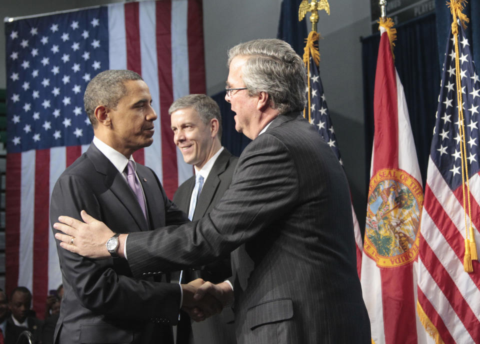 President Barack Obama is introduced by former Florida Gov. Jeb Bush before speaking at Miami Central Senior High School in Miami, Friday, March 4, 2011. Education Secretary Arne Duncan is at center. (AP Photo/Pablo Martinez Monsivais)