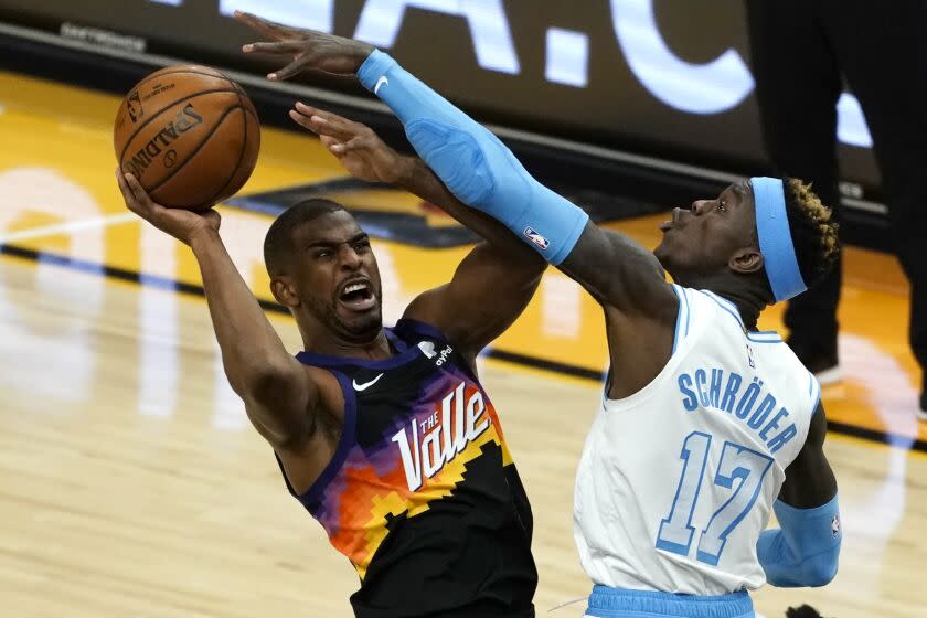Phoenix Suns guard Chris Paul gets fouled by Los Angeles Lakers guard Dennis Schroder (17) during the second half of an NBA basketball game, Sunday, March 21, 2021, in Phoenix. (AP Photo/Rick Scuteri)